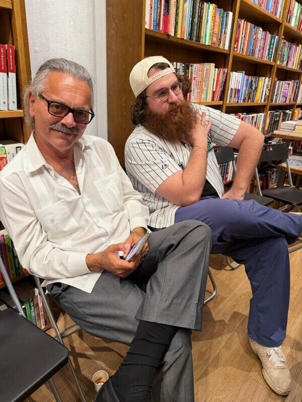 Chris at a literary event surrounded by books